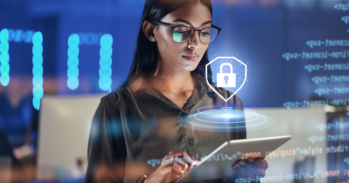 A woman stands with a tablet in her hands. A lock graphic hovers over the screen as she looks at it.