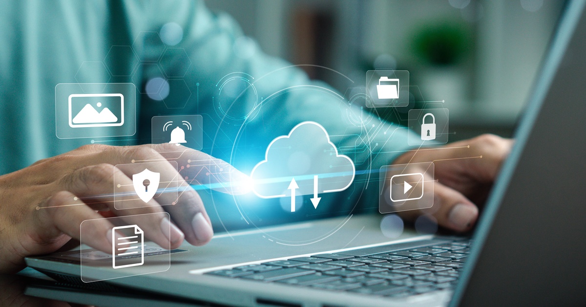 A close-up of someone's fingers typing on a keyboard. A cloud graphic and various file graphics hover over the keyboard.